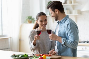 Mutlu genç adam karısıyla kadeh tokuşturuyor..