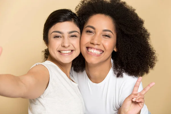 Indian happy girl taking selfie with smiling african american friend. — Stock Photo, Image