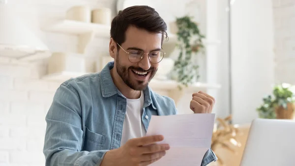 Happy young man reading paper letter with good news. — Stock Photo, Image