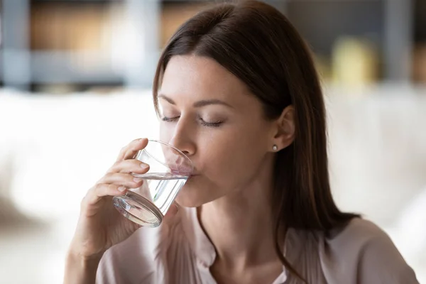 Здоровая молодая женщина пьет чистую минеральную воду — стоковое фото