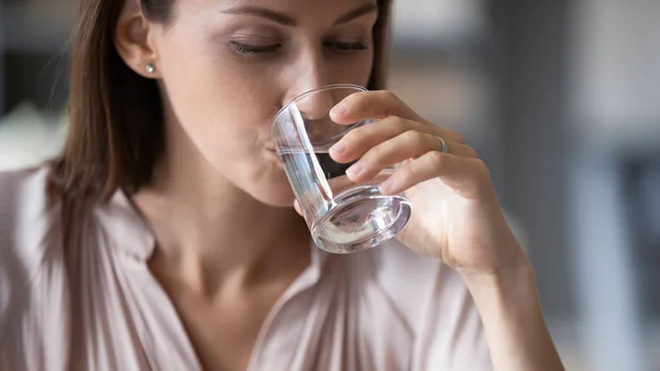 Młoda kobieta czuje pragnienie pić spokojną wodę mineralną — Zdjęcie stockowe