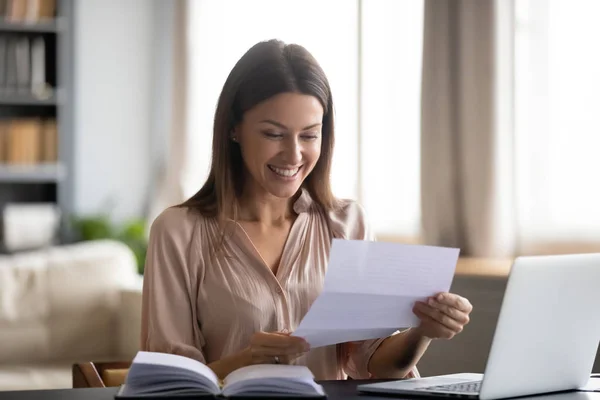 Leende ung kvinna läsa goda nyheter i brev — Stockfoto