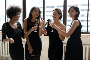 Gülümseyen çeşitli elbiseli kız bekarlığa veda gecesini kutluyor.