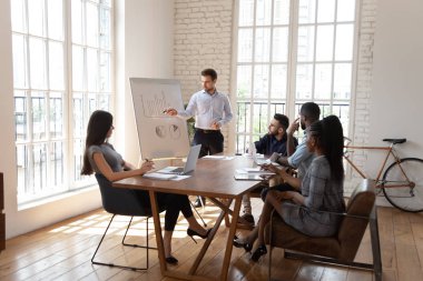 Erkek koç farklı çalışanlara beyaz tahta ofis sunumu yaptı