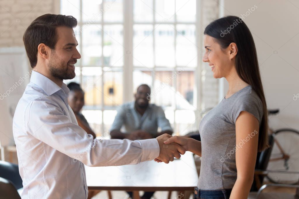 Male boss handshake female employee greeting with promotion
