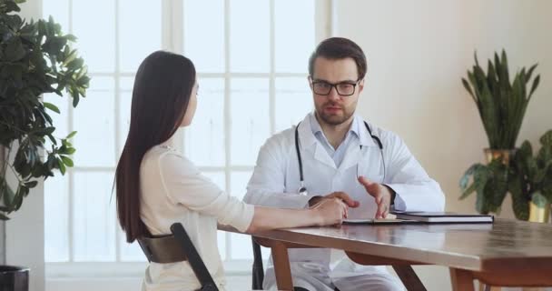 Médico masculino conversa com paciente jovem na consulta médica — Vídeo de Stock