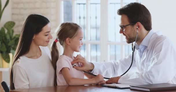 Smiling doctor pediatrician holding stethoscope exam little child girl patient — Stock Video