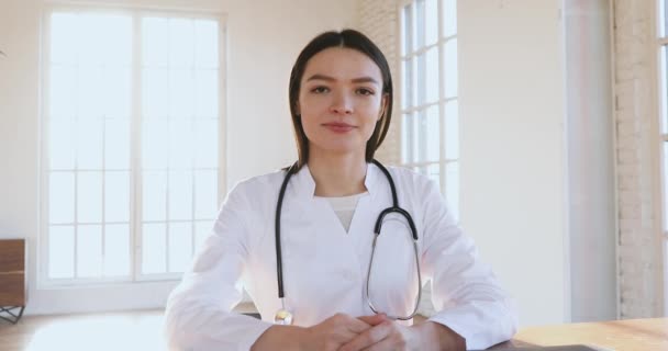 Mujer joven médico hablando con webcam ayudando a paciente en línea — Vídeos de Stock