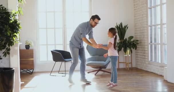 Unbekümmerter junger Vater und kleine Tochter haben Spaß beim gemeinsamen Tanzen — Stockvideo