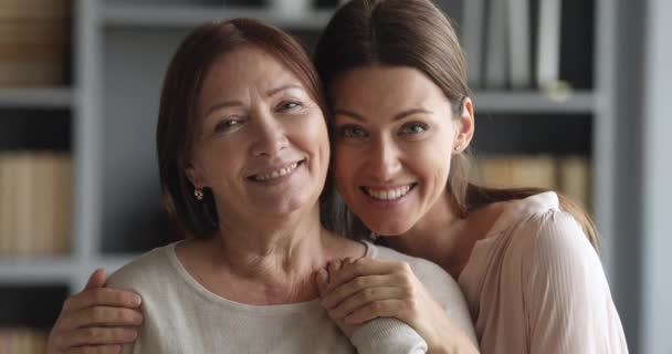Mooi volwassen dochter knuffelen ouder volwassen mam kijken naar camera — Stockvideo
