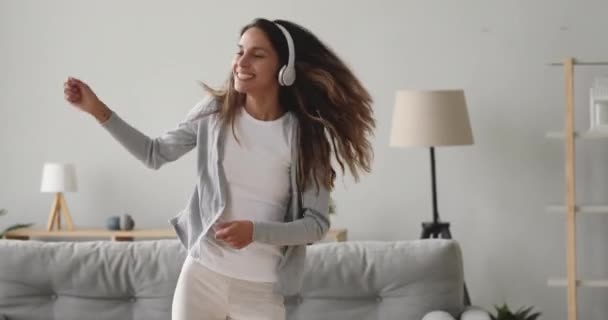 Gelukkig energiek gemengd ras meisje genieten van dansen op favoriete muziek. — Stockvideo