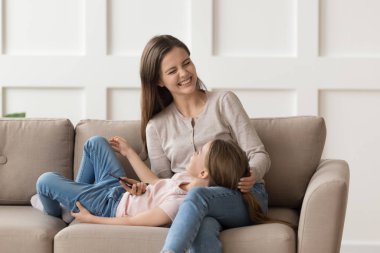 Küçük kız mutlu bir anne gibi dizlerinin üzerine çöküp birlikte eğleniyor.