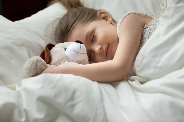Cute little girl, peaceful child sleeping in bed, hugging toy — Stock Photo, Image