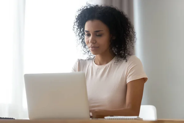 Mujer africana pasar tiempo en Internet utilizando la computadora de chat en línea — Foto de Stock