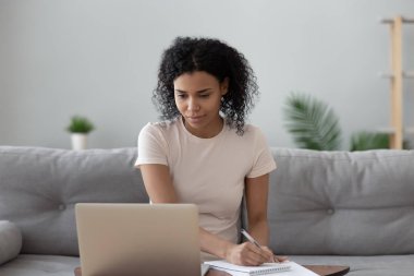 Afrikalı kadın bilgisayarlara bakıyor. Uzaktan kumanda işi yapıyor.