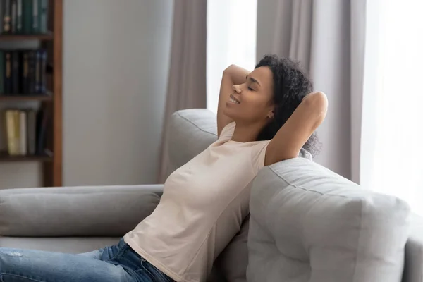 Side view serene african woman leaned on couch resting — Stock Photo, Image