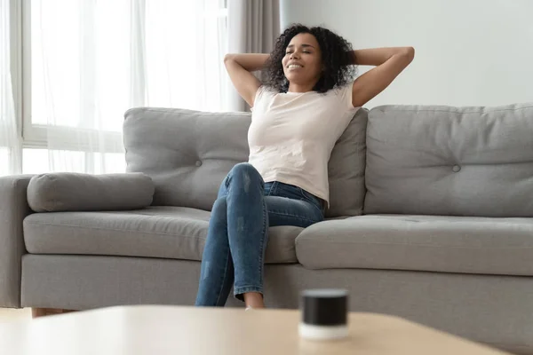 Serene Afrikaanse vrouw leunde op de bank rusten in de woonkamer — Stockfoto