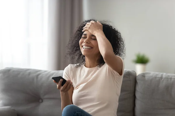 African woman laughs at funny video or joke prank online — Stock Photo, Image