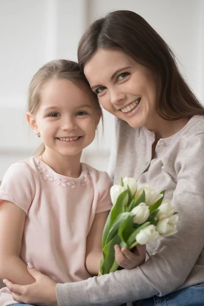 Головний постріл портрет матері і маленької дочки з квітами вертикально — стокове фото