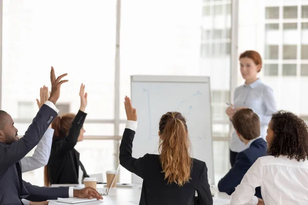 Employees raise hands answering questions at office training — Stock Photo, Image