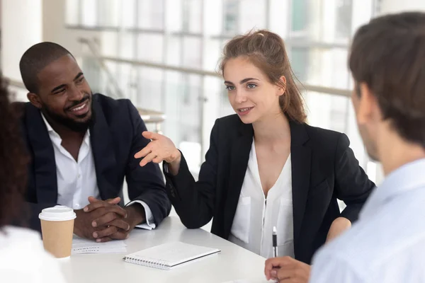 Female employee talk discussing ideas with colleagues at meeting — Stock Photo, Image