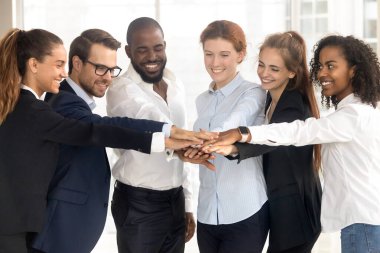 Heyecanlı çok ırklı çalışanlar destek ve birlik içinde el ele tutuşuyorlar