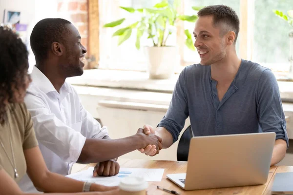 Sonriendo multirracial colegas masculinos saludo apretón de manos en la reunión — Foto de Stock