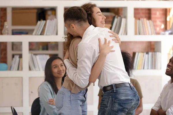 People stand hugging showing support at psychological group session — ストック写真