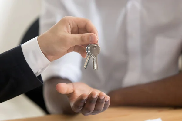 Close up of realtor give keys to property buyer