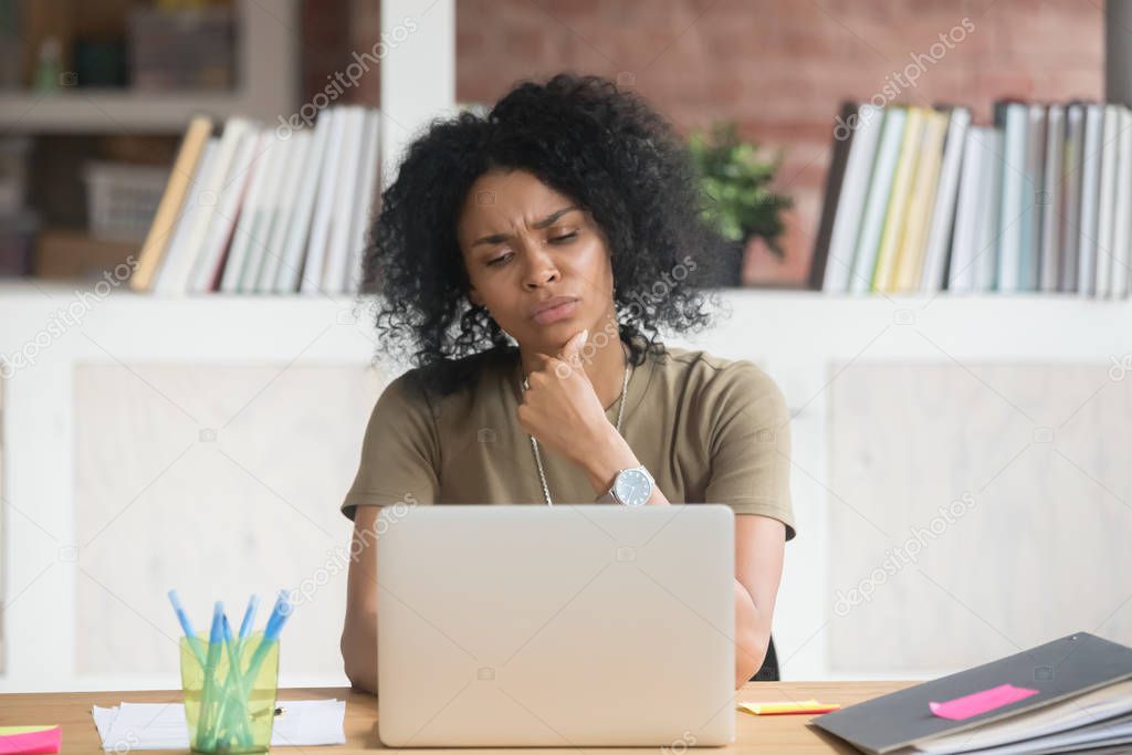 Pensive black woman work at laptop thinking making decision