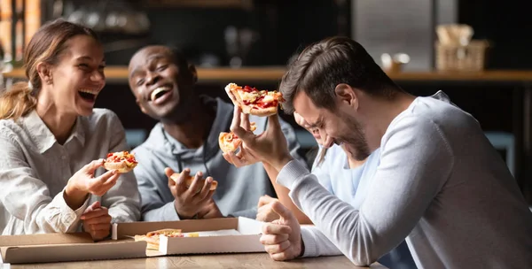 Happy multiraciale vrienden genieten van lekkere pizza van afhaalmaaltijden — Stockfoto