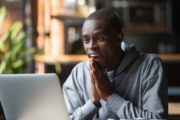 Возбужденный черный мужчина удивлен, читая новости бога в электронной почте — стоковое фото