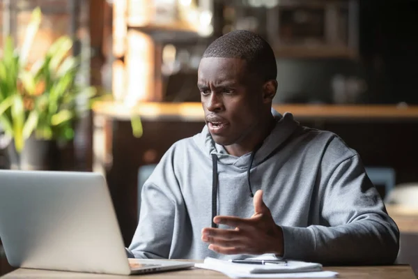 Разгневанный чернокожий парень, имеющий проблемы с программным обеспечением ноутбука — стоковое фото