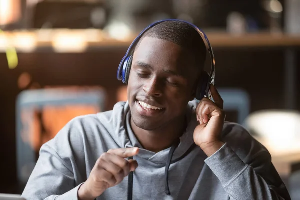 Feliz amante da música negra ouvir a faixa em fones de ouvido Bluetooth — Fotografia de Stock