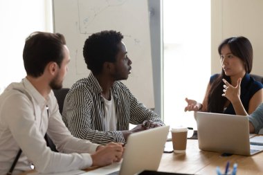 Çok ırklı çeşitli çalışanlar toplantıda beyin fırtınası yapıyorlar.