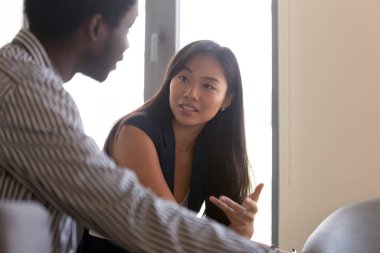 Milenyum Asyalı kadın, erkek iş arkadaşıyla iş birliği yapıyor.