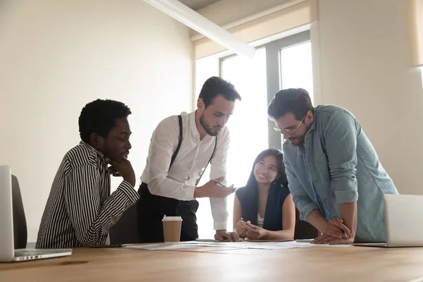 Des employés multiraciaux discutent de remue-méninges lors d'un briefing d'équipe au bureau — Photo