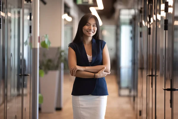 Lächelnde asiatische Geschäftsfrau posiert im Büroflur — Stockfoto