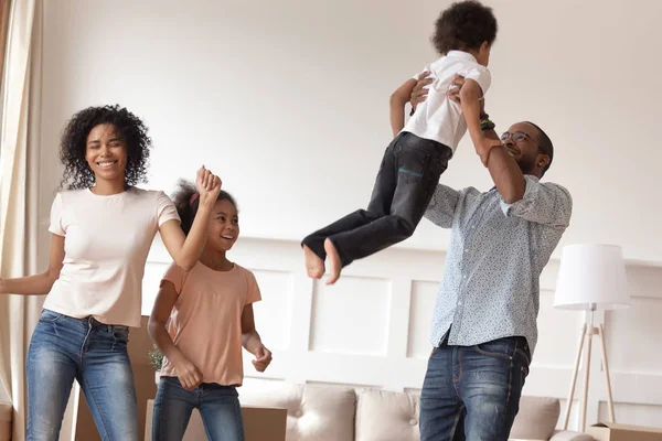 Overjoyed smiling black family celebrating moving in new house. — Stock Photo, Image