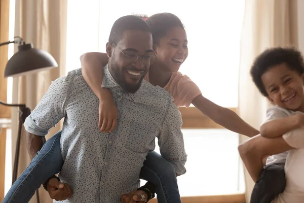 Gros plan heureux père noir avec fille sur le dos . — Photo