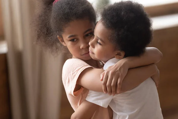 Mixed race girl hugging upset smaller brother. — Stock Photo, Image