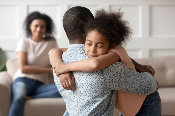 Little school girl embracing mixed race father. — Stock Photo, Image