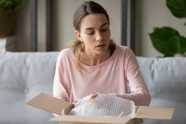 Millennial chica desempacar paquete con cosas frágiles . —  Fotos de Stock