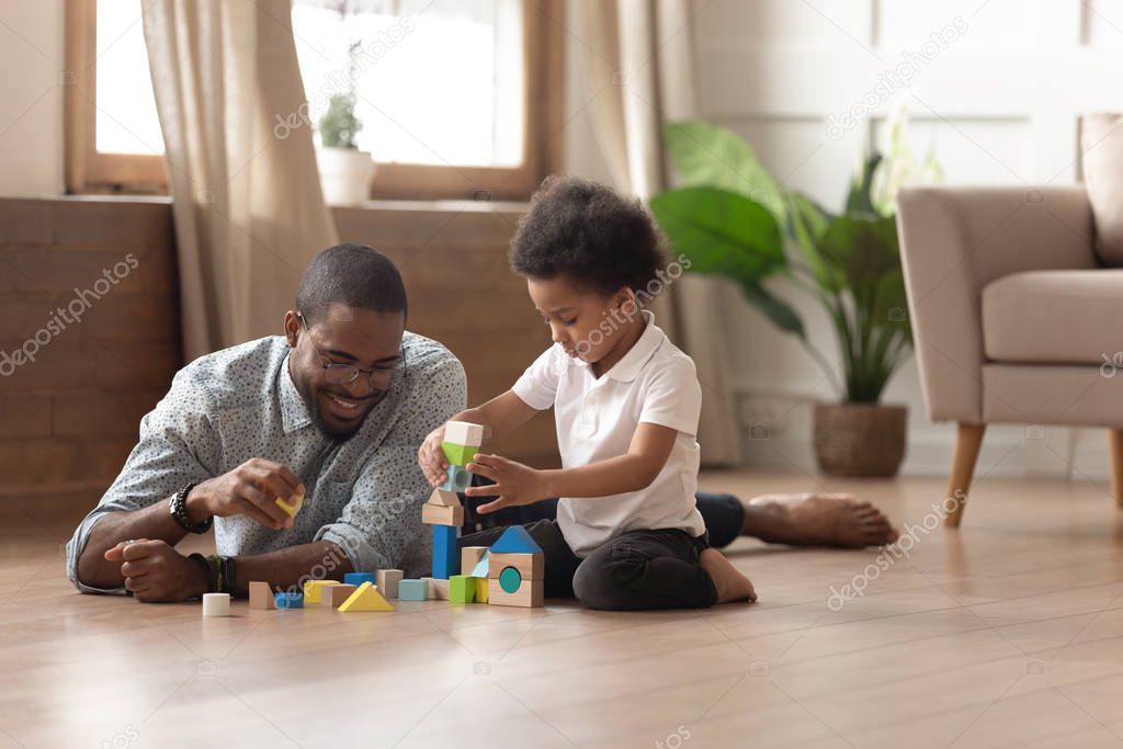 Black happy man playing with small cute son.