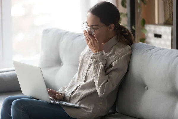 Mujer joven cansada bostezando, sintiéndose soñolienta mientras trabaja con la computadora . — Foto de Stock