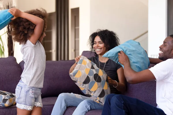 Happy African American family have fun in pillow fight