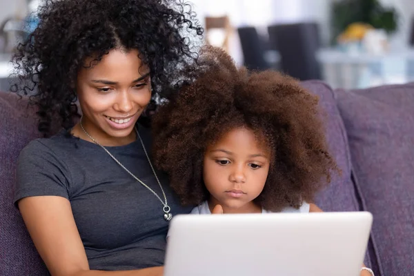 Afro-americano mãe e filha relaxar usando laptop juntos — Fotografia de Stock