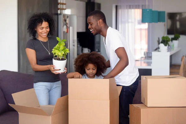 Feliz familia afroamericana desempacando cajas después de mudarse —  Fotos de Stock