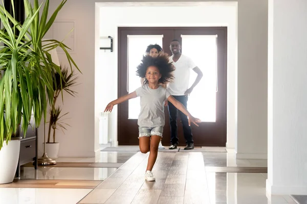 Pequena menina feliz correr no corredor movendo-se para a nova casa — Fotografia de Stock