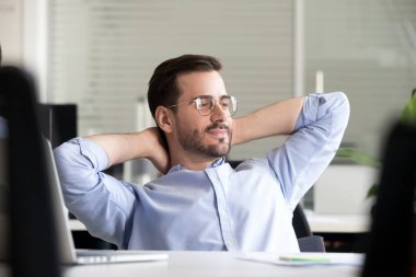 Düşünceli erkek işçi. Ofis sandalyesinde rahatlayıp hayal kuruyor.